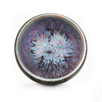 Zen tea ceremony featuring the Iridescent Bloom Jian Zhan teacup with traditional green tea.